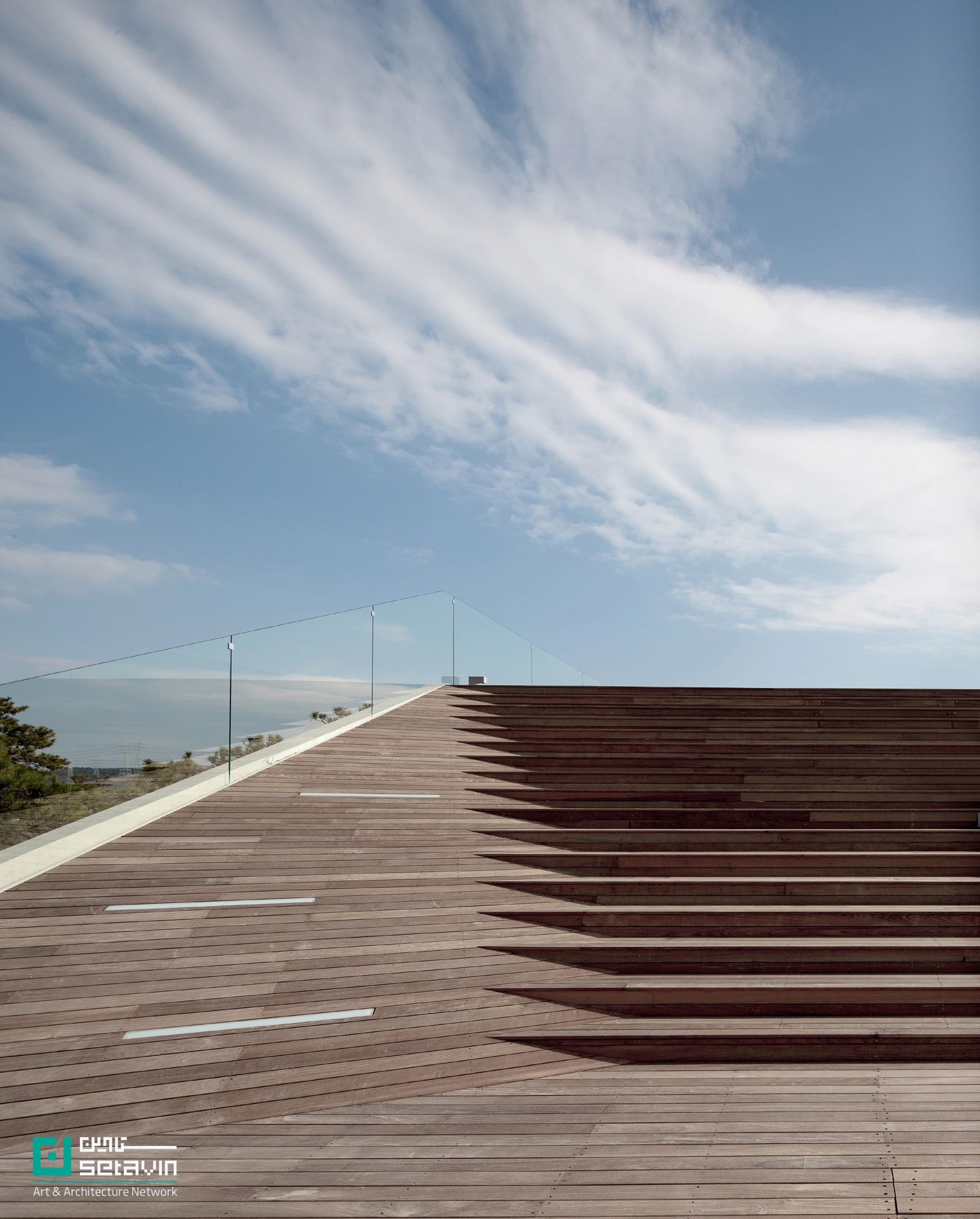 کافه Gijang Waveon در نزدیکی بوسان کره‌جنوبی، اثر Heesoo Kwak + IDMM Architects؛ حجمی پله‌پله با راهروهای طولانی، void مرکزی و سکوهای سنتی زیر کاج، برای تماشای چندلایه دریا و ساحل.